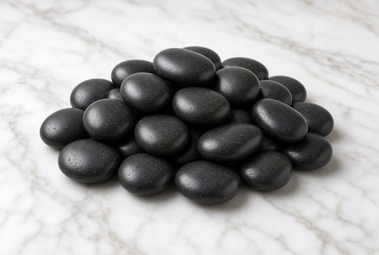Black river rocks pile on marble - product photo